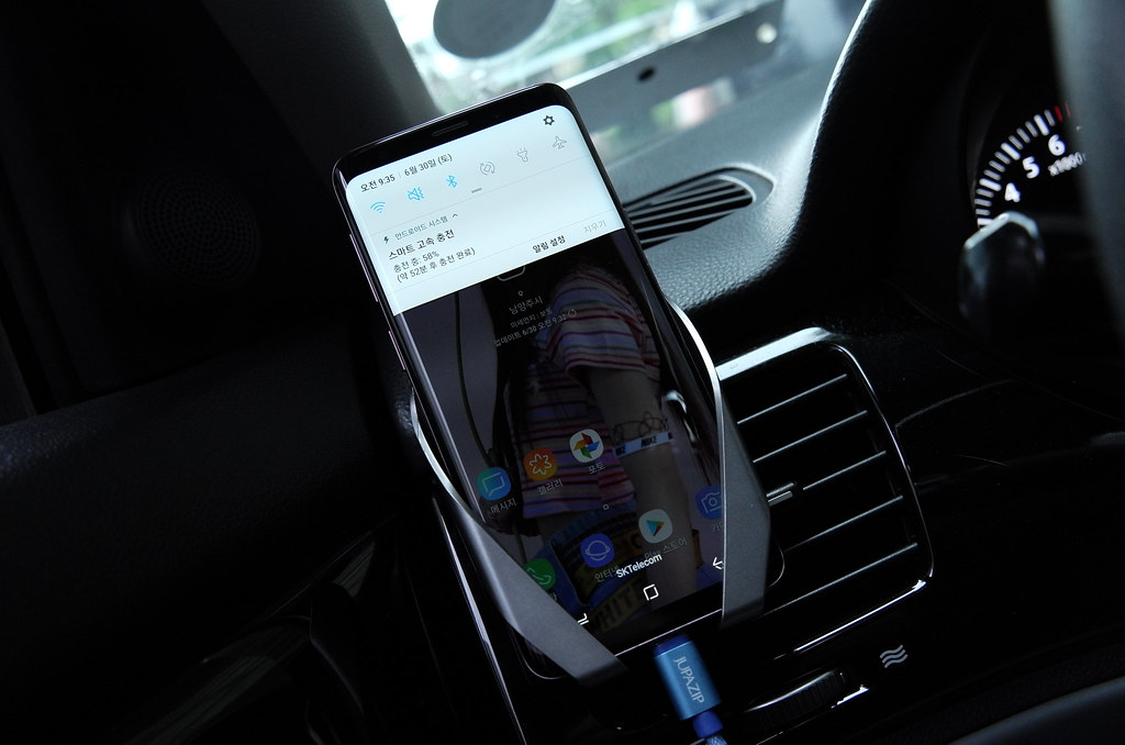 Car charger plugged into a vehicle dashboard with a smartphone charging on a road trip.